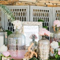 vases filled with flowers sitting on top of a table next to pictures and frames