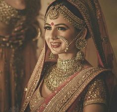 a woman in a bridal outfit with jewelry on her neck and headpieces