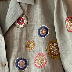 an embroidered shirt with colorful circles on the chest and collar, along with other buttons