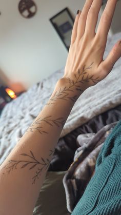 a woman's arm with a tattoo on it and her hand in the air