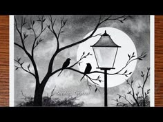 two birds sitting on a tree branch in front of a street light with the moon behind them