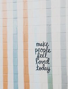 the words make people feel loved today are painted on a wall with multicolored stripes