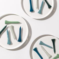 three plates with different shapes and sizes of toothbrushes in them on a white surface