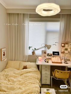 a bed sitting under a window next to a desk with a laptop on it and a lamp above it