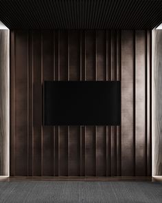 an empty room with a flat screen tv on the wall and wooden paneled walls