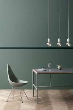 a dining room with green walls and wooden flooring, two chairs at a table