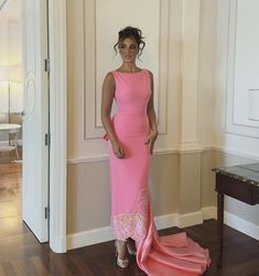 a woman in a pink dress posing for the camera