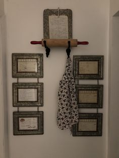 the coat rack is hanging on the wall next to several framed pictures and a paper towel