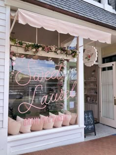 a store front window with pink and white decorations