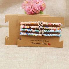 the bracelets have been made with beads and are on display in front of a flower