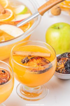 an apple cider is garnished with cinnamon and apples