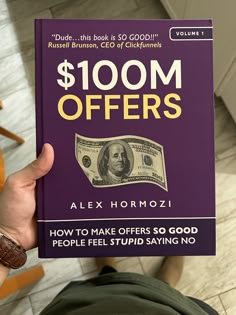 a person holding up a book about $ 100m offers