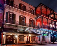 an old building lit up at night with lights on the windows and balconies