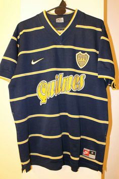 a shirt hanging on a wall with the word quilimes written in yellow and blue