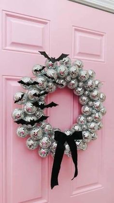 a pink door with a silver and black wreath on it