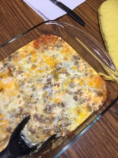 a casserole dish with cheese and meat in it on a table next to a banana