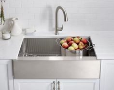 a stainless steel kitchen sink with apples in it