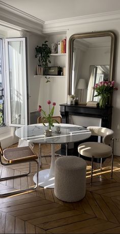 a dining room table with chairs and a mirror on the wall next to a piano