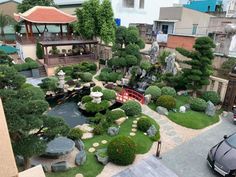 an aerial view of a garden with trees, rocks and water features in the center