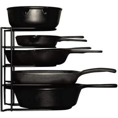 black pots and pans are stacked up on a metal rack against a white background