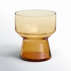 a yellow glass cup sitting on top of a white table