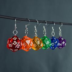 "These handmade D20 charm earrings are perfect for any TTRPG fan, cosplayer, or enthusiast! Length Charm: 2cm  Material: 925 sterling silver ear hooks/hoops Hoops: 20 or 10mm ♦️colors might be different due to light and angle♦️ Prio German shipping/Tracked shipping everywhere else Free Shipping on orders over 35€ worldwide with code \"ISHIPIT35\" !" D20 Dice, Ear Hook, Charm Earrings, Star Fashion, Jewelry Crafts, Jewelry Earrings Dangle, Dangle Drop Earrings, Dangle Earrings, Rainbow