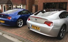 two cars parked next to each other in front of a brick building on the street