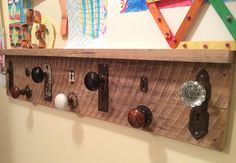 a wooden shelf with several knobs and handles on the bottom, hanging from it's sides