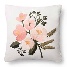 a white pillow with pink flowers and leaves painted on it's front, sitting on a white surface