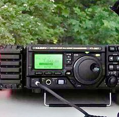 an old radio sitting on top of a table next to a green screen and some trees