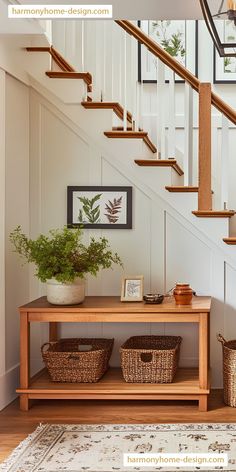 a wooden table sitting under a stair case next to a bannister and potted plant