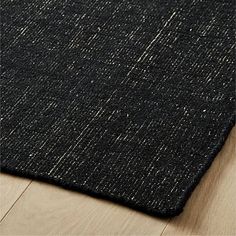 a black and white rug on top of a wooden floor next to a wood floor