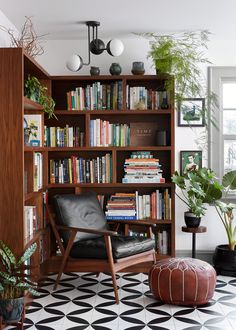 a living room filled with lots of books and plants