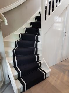 there is a black and white stair runner on the stairs