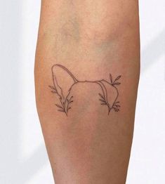 a small tattoo on the leg of a woman's legs, with leaves coming out of it