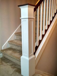 a white bannister next to a set of stairs in a room with carpet on the floor