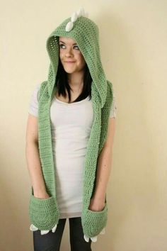 a woman wearing a green crocheted hoodie with horns on it's head