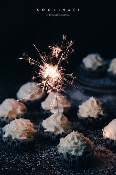 some cupcakes with white frosting and sparklers