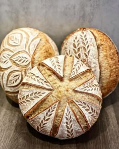 three loaves of bread sitting on top of a wooden table