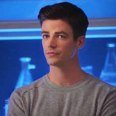 a young man is staring at something in front of him with blue lights behind him