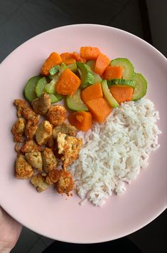 a white plate topped with rice and veggies next to cucumber slices