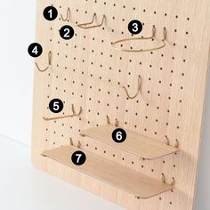 a wooden peg board with hooks and numbers on it