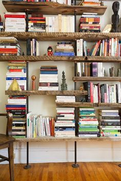 a bookshelf filled with lots of books next to a wooden chair