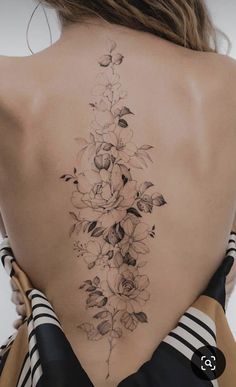 the back of a woman's neck with flowers on it