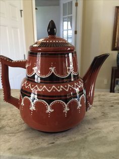 a red tea pot sitting on top of a counter