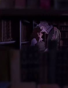 a man and woman standing next to each other in front of a bookshelf