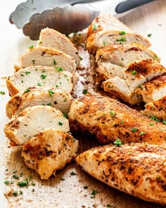 sliced chicken on a cutting board next to a knife