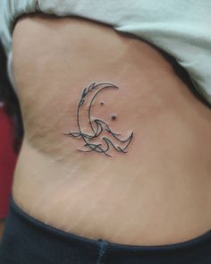 a woman's stomach with a small wave tattoo on her lower back and side