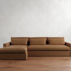 a couch sitting on top of a hard wood floor next to a white wall in an empty room