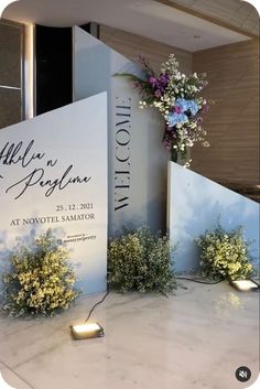 flowers are placed on the table in front of a sign